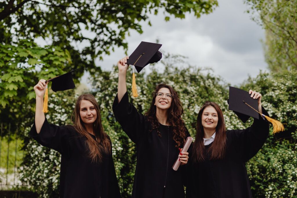 Tres graduadas celebran con birrete y diploma