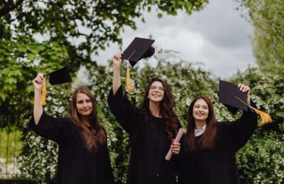 Tres graduadas celebran con birrete y diploma
