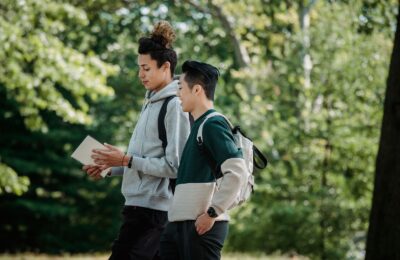 Dos estudiantes con mochila caminan por el campus